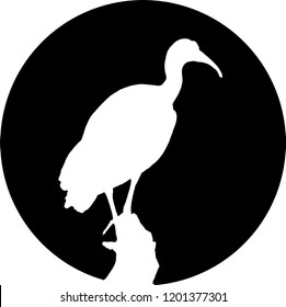 Silhouette of Hern bird on branch. White in black circle.