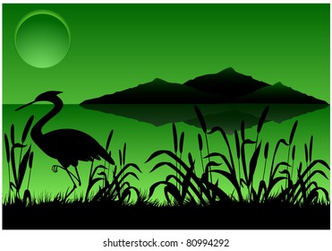 Silhouette of heron in canes on background of mountains and full moon