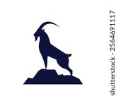 silhouette of an ibex standing on a mountain peak