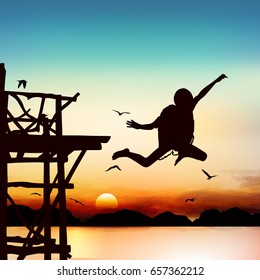 Silhouette and jumping boy in the twilight with blue sky.