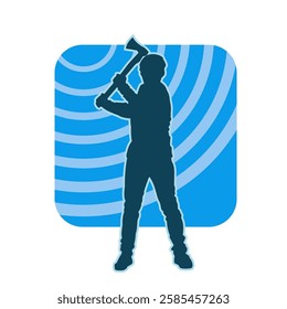 silhouette of a male lumberjack holding broad axe tool. silhouette of a forest worker standing ang holding a tomahawk.