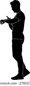 Silhouette of a man checking a smartwatch while standing, modern wearable technology and lifestyle concept