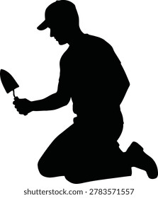 Silhouette of a man kneeling and praying while holding a trowel
