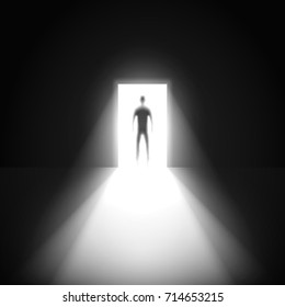 Silhouette of man and open door in a dark room with light going through it.