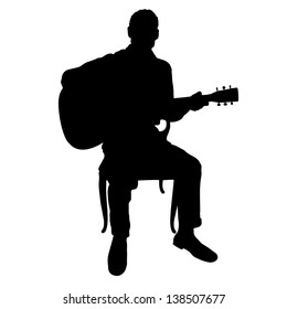 Silhouette of a man playing an acoustic guitar