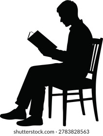 Silhouette of a man reading a book while sitting on a chair