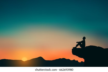 Silhouette Of Man Sitting On Mountain Cliff Looking At Sunset Sky Background