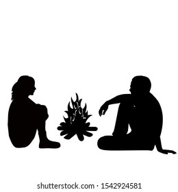 Silhouette of a man and woman sitting by the fire