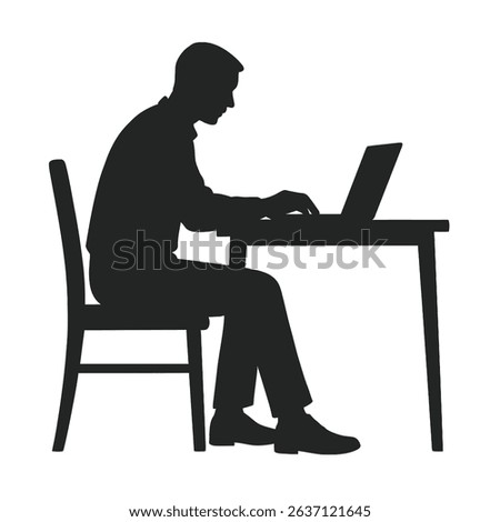 Silhouette of a man working on a laptop computer at a desk