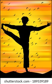 Silhouette of man in yoga pose at sunset 