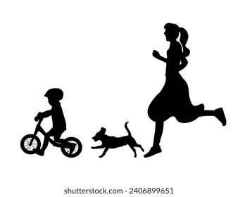 Silhouette of a mother and a dog chasing a child riding a balance bike