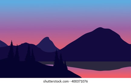 Silhouette of mountain by the lake at night