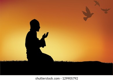 Silhouette of a Muslim praying during sunset.