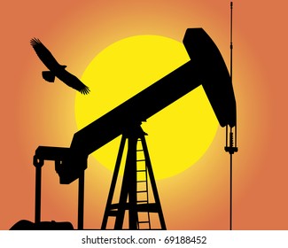 Silhouette of the oil pump against the sun and a flying bird