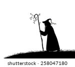 silhouette of  old wizard with tree stick on white background