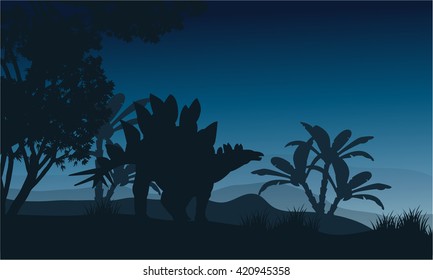 Silhouette of one stegosaurus in fields at night