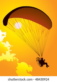 Silhouette of a paraglider at sunset
