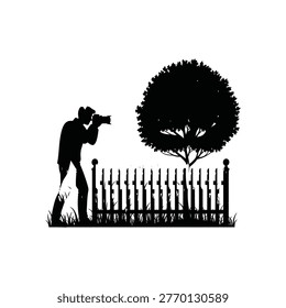 Silhouette of a photographer capturing a scene behind a fence