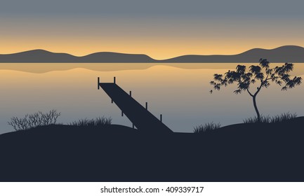 Silhouette of pier in lake at the sunset