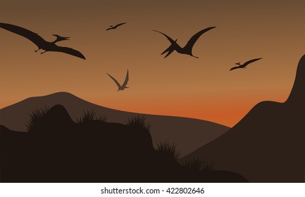 Silhouette of pterodactyl flying at afternoon with brown backgrounds