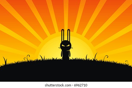 Silhouette of rabbit and grass on sunrise background