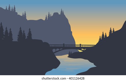 Silhouette of river and bridge at sunrise