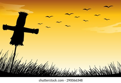 Silhouette scarecrow on the field with sunset