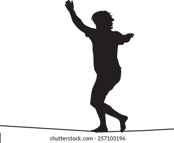 Silhouette of slackiner walking on tightrope