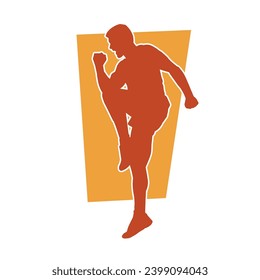 Silhouette of a sporty male in action pose at the gym. Silhouette of a slim man in aerobics workout pose.