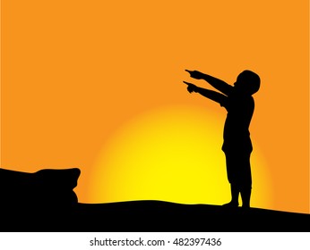 Silhouette of standing boy with hand pointing on sunset.