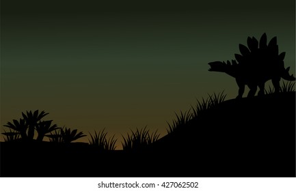 Silhouette of Stegosaurus in fields scenery at the night