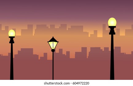 Silhouette of street lamp with city scenery