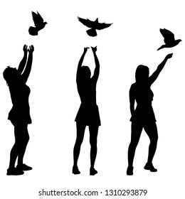 Silhouette of three girls let a dove in the sky