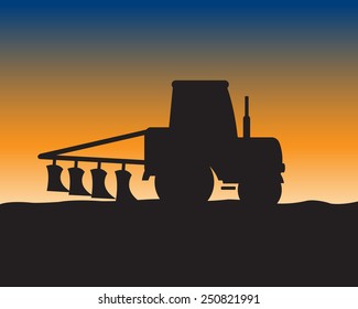 Silhouette of the tractor with plow on background of the field