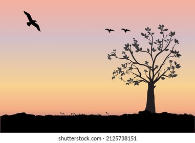 silhouette of a tree flowers and grass with birds and a butterfly and a sunset background