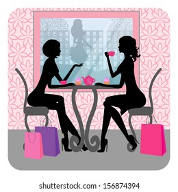 Silhouette of two beautiful girls talking in a cafe 