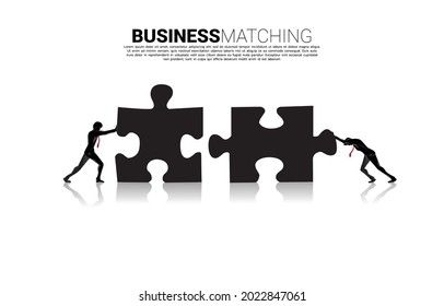 Silhouette of two businessman pushing two jigsaw pieces puzzle. concept of business teamwork.