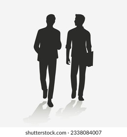 Silhouette of two men walking while chatting