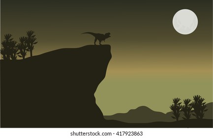 Silhouette of tyrannosaurus in cliff with moon