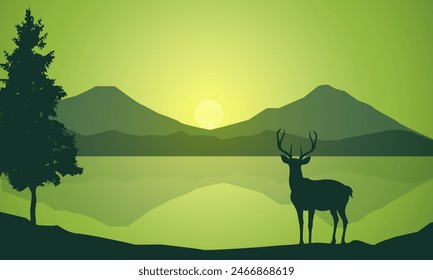 Silhouette of wild deer with trees on the edge of the lake and beautiful mountains in the morning,evening, sunset,sunrise