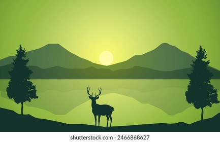 Silhouette of wild deer with trees on the edge of the lake and beautiful mountains in the morning,evening, sunset,sunrise