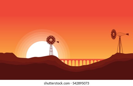 Silhouette of windmill and bridge