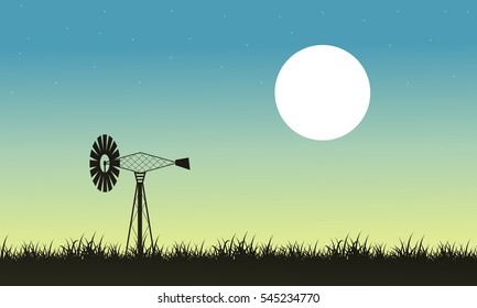 Silhouette of windmill and grass landscape