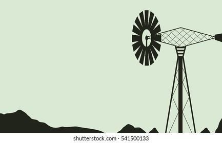 Silhouette of windmill on farm landscape