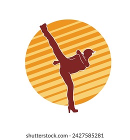 Silhouette of a woman doing a martial art kick. Silhouette of a sporty female doing kicking movement.
