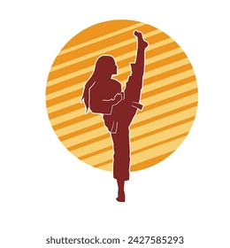 Silhouette of a woman doing a martial art kick. Silhouette of a sporty female doing kicking movement.
