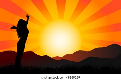 Silhouette of a woman with her arms in the air at sunset