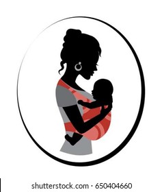 Silhouette of a woman holding a baby in a sling