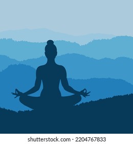 Silhouette of a woman meditating in the mountains in twilight.