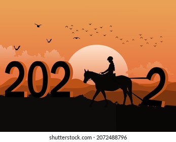 Silhouette of a woman riding a horse using a rope to drag the number two up the mountain. The number 2022 on it has mountains and sunset in the background.